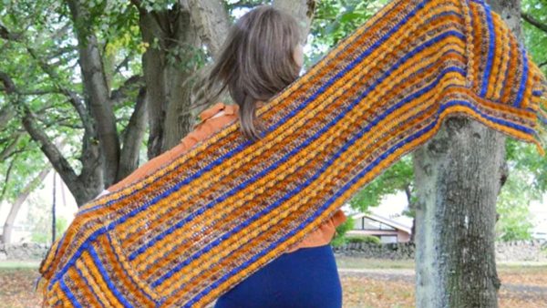 a woman holding the Autumn Berries Crochet Pocket Shawl