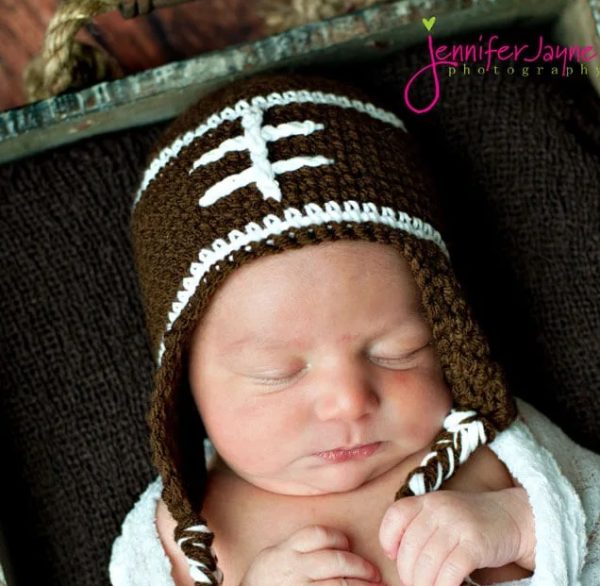 a baby wearing a football crochet hat