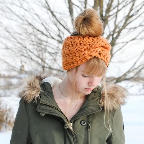 A woman wearing the Glacier Twist Crochet Headband