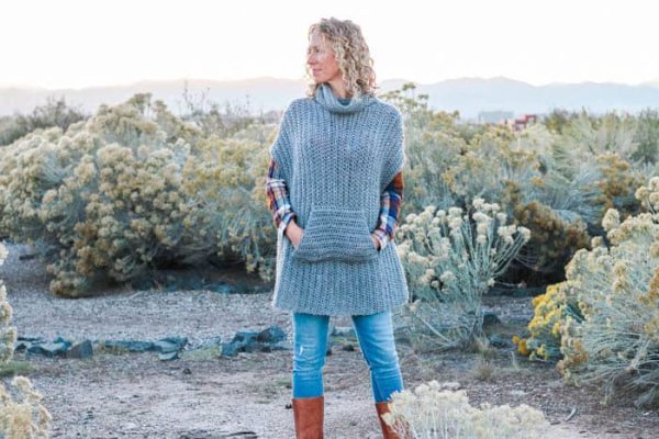 A woman wearing the Greyscale Crochet Poncho