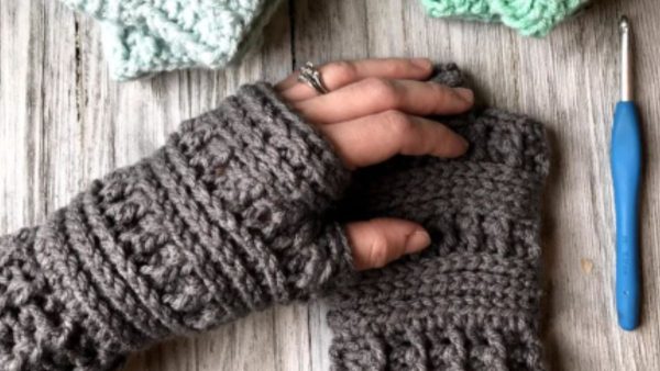 woman wearing gray crochet fingerless gloves