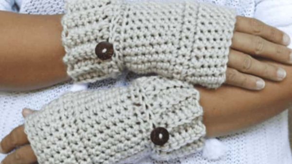 a person wearing crochet fingerless gloves with a little buttons